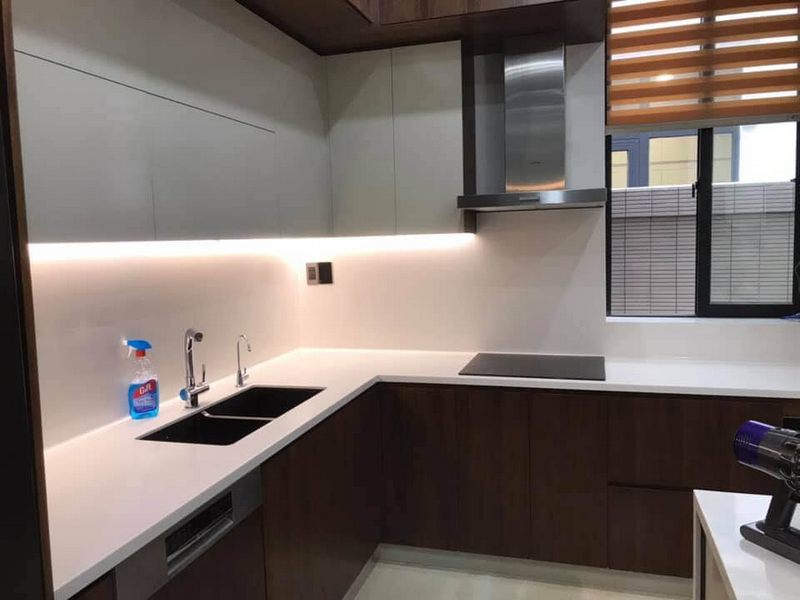 Việc sử dụng đá mặt bếp liền khối và đá ốp tường bếp giúp tạo nên sự đồng bộ trong thiết kế không gian bếp.